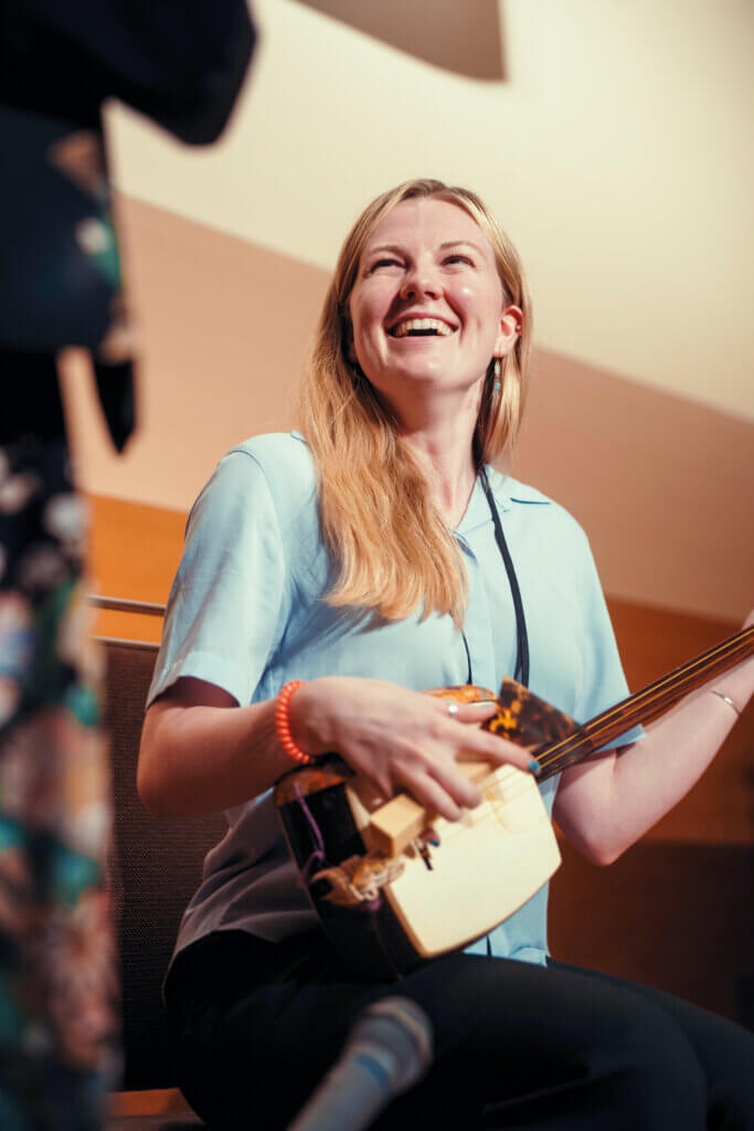 Emily Aldous tries her hand at playing the shamisen, a three-stringed instrument, at the Onuma Prince Hotel. Photo by Yotam Ivan