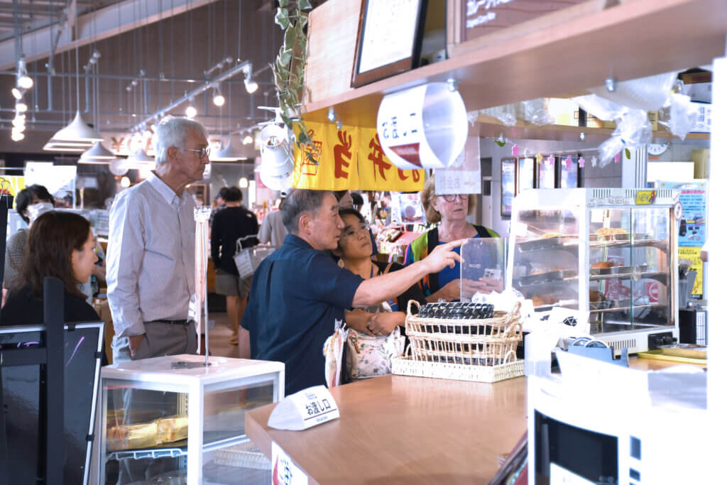 Toshiro Yamakawa shows Acton guests the menu at Nanae Michinoeki. Photo courtesy of Jack Brox McCarthy
