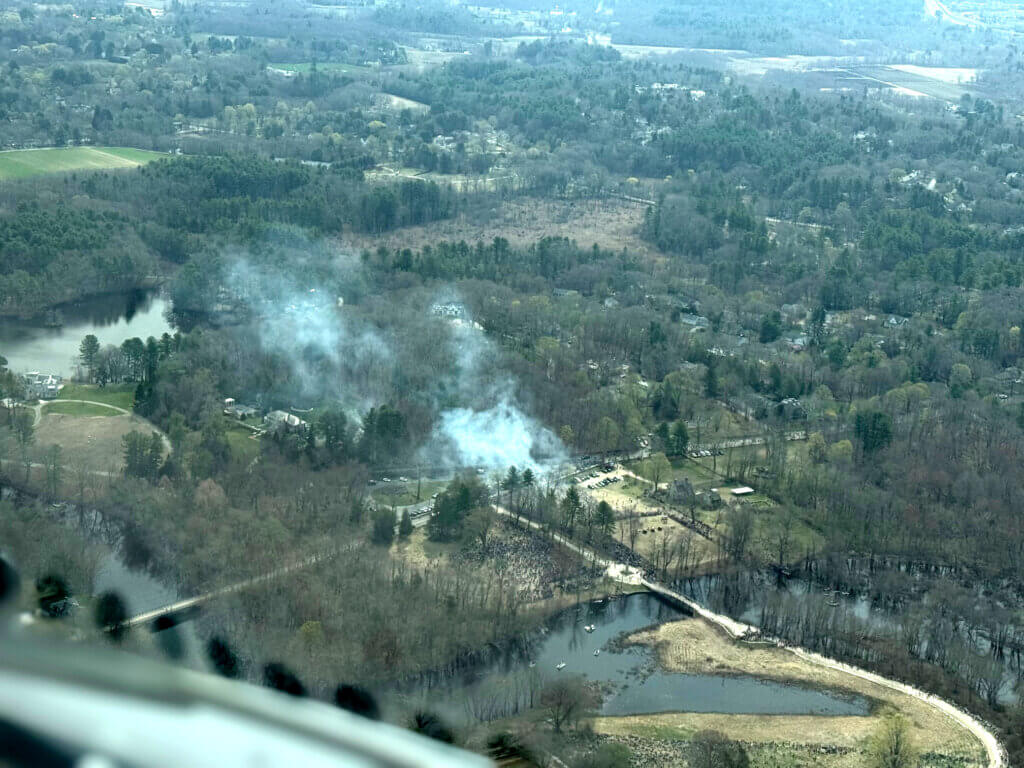An aerial view from a New Hampshire Air National Guard refueling tanker captures smoke drifting over Minute Man National Historical Park following Concord250 cannon firings. Image via New Hampshire Air National Guard