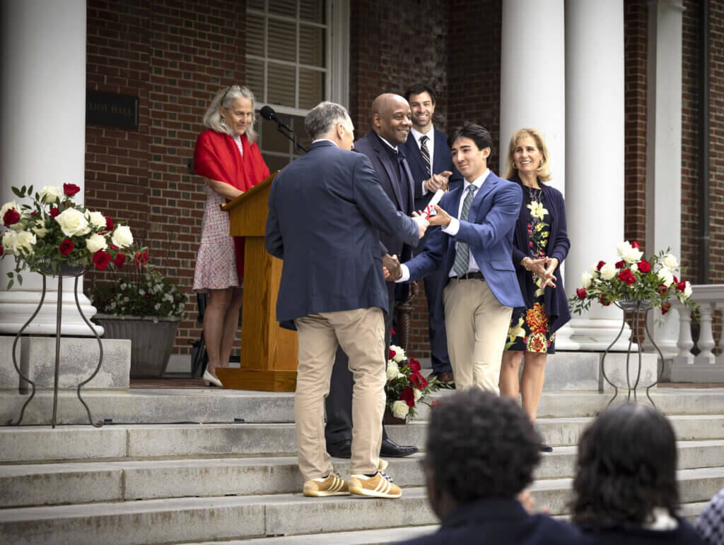 Oliver Mylon of Acton receiving his Middlesex School diploma from his father, science department chair Steven Mylon. Behind them, (l to r), are Associate Head of School Karlyn McNall, Board Chair Jason Robart '83, Assistant Head of School Eric Kester '04, and Head of School Bessie Speers. Courtesy photo