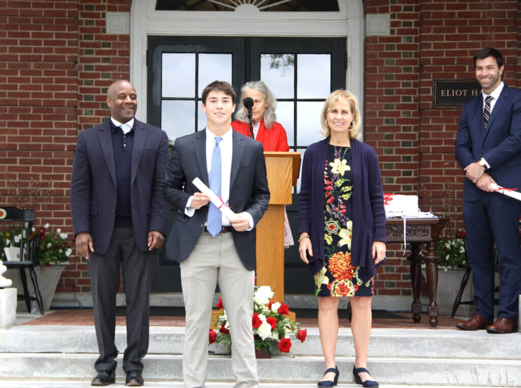 Diploma in hand, Thomas Donahue of Acton pauses for a photo with Middlesex's Board Chair Jason Robart '83 and Head of School Bessie Speers. At the podium is Associate Head of School Karlyn McNall. Courtesy photo