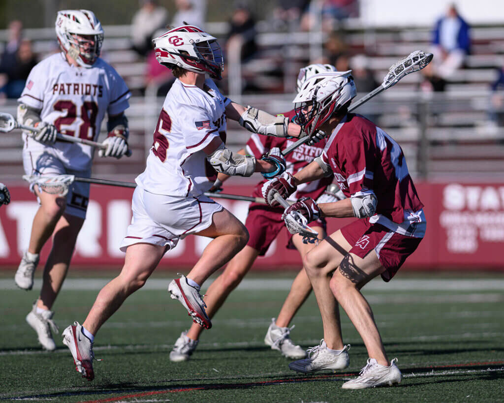 CCHS’ Charlie Lynch (No. 26) drives against Westford Academy’s Samuel Bramanti (24) during the May 7 match. Photo by Jon Straggas