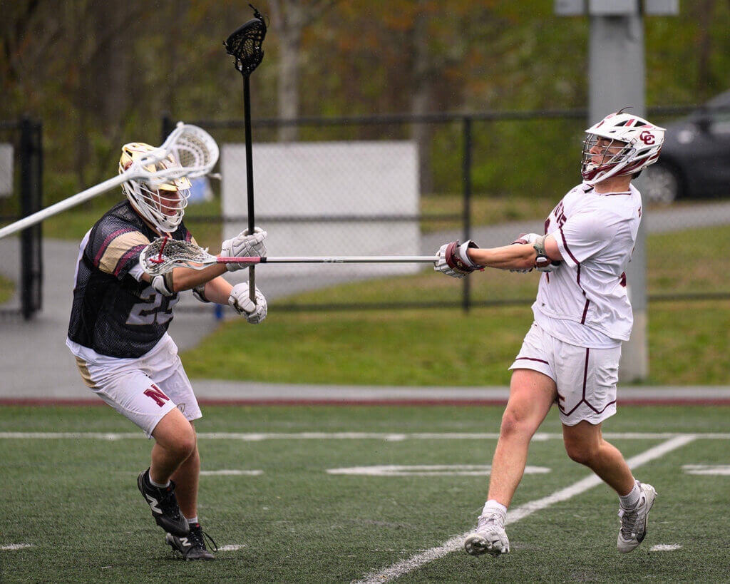 Acton-Carlisle’s Sam Griswold (No. 1) shoots and scores with Newburyport’s Aidan Martyn (No. 23) defending during last Saturday’s Senior Day game. Photo by Jon Straggas