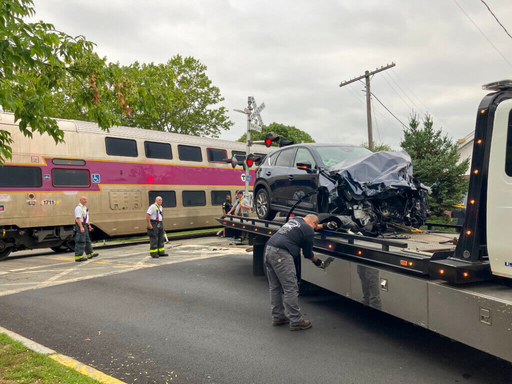 A tow truck driver secures the damaged vehicle onto the loading bed. Photo: Dakota Antelman/The Acton Bridge