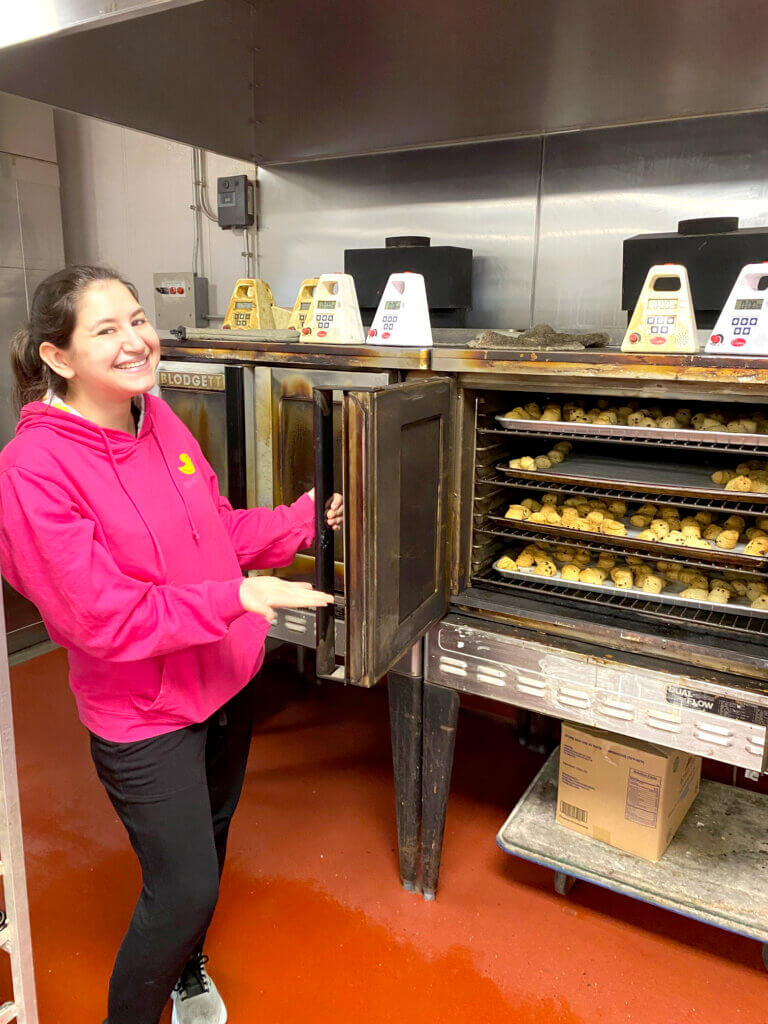 Olivia Strauss unveils a recent batch of raisin scones. Photo by Margaret Carroll-Bergman