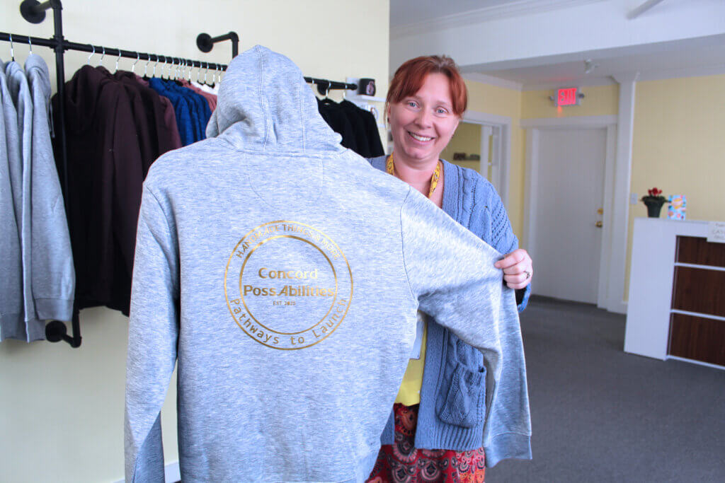 Launch program director Radka Grein holds up a sweatshirt for sale at Acton PossAbilities. Photo: Laura Hayes/Acton Bridge