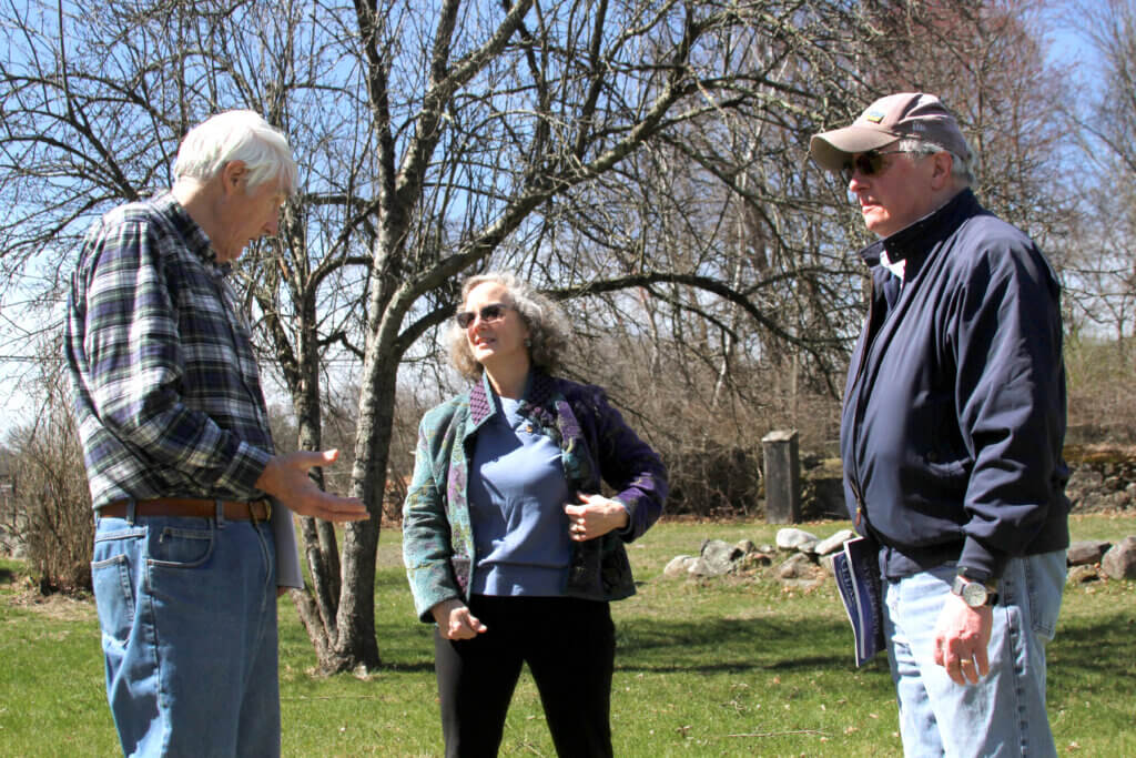 Longtime Acton resident Mark Giddings (left) speaks with Select Board member Wendy Rovelli and her husband, Mark. Photo: Dakota Antelman/The Acton Bridge