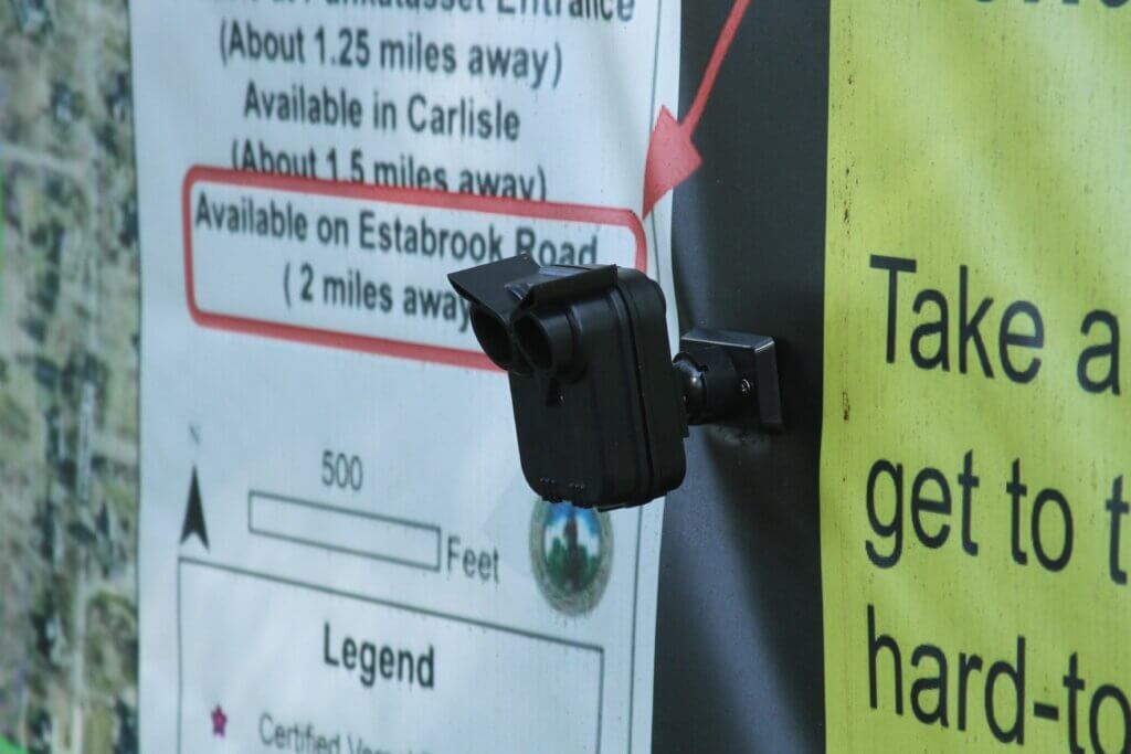 Abutters’ surveillance gadgets keep watch over Estabrook Trail from trees and signs about the access case. Photo: Dakota Antelman/The Acton Bridge