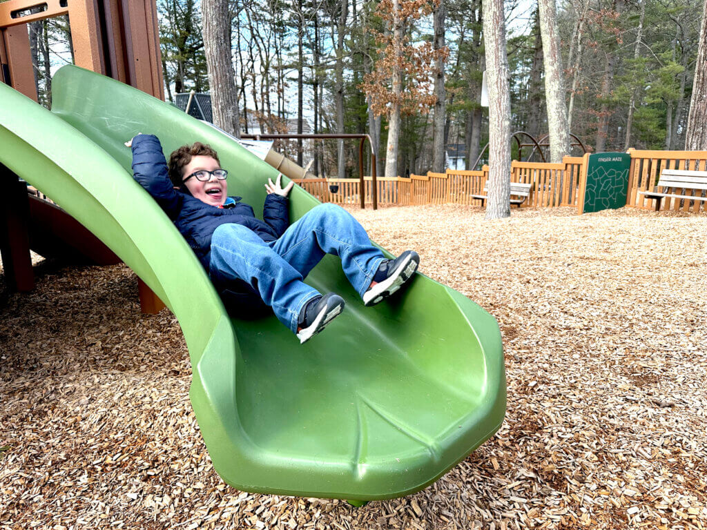 Ethan Martinelli plays on a slide. Photo: Laura Hayes/Acton Bridge.
