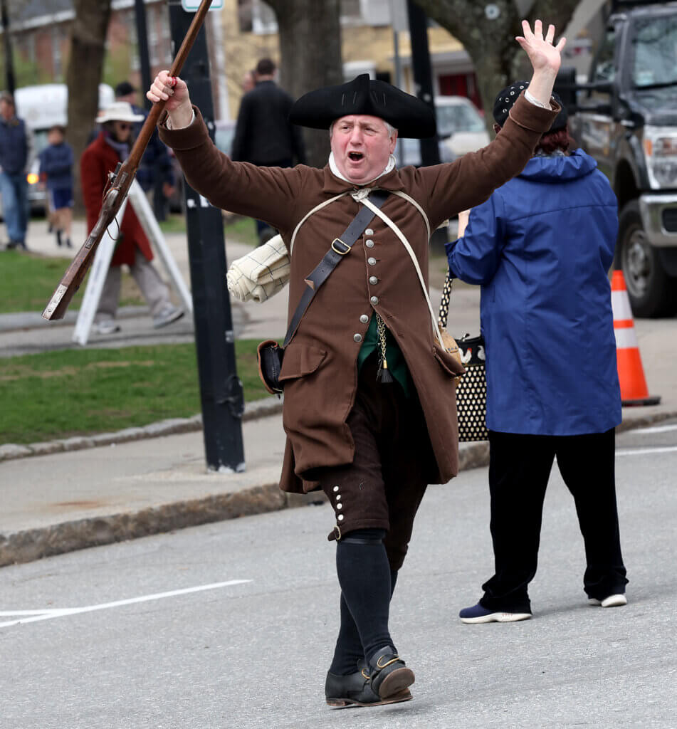 Reenactor Peter Secor throws his hands in the air during the outdoor concert.
