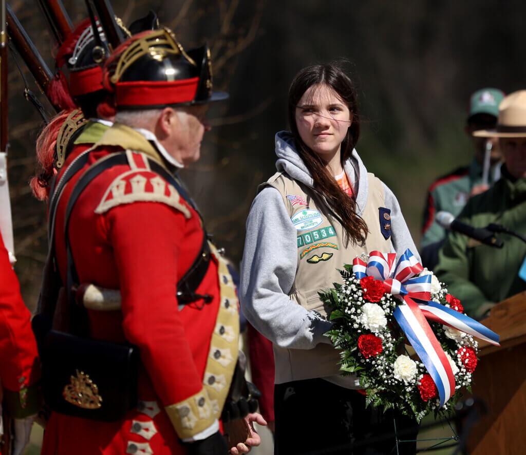 Acton Girl Scout Claire Ahlin, 13, prepares to assist British Regulars in laying a wreath at the grave of fallen British soldiers.  
