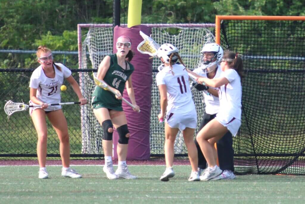 Defenders Julia Reynolds (21), Alex Skelly (11) Isabella Couto (17) and goalie Alex Hooven surround a Bishop Feehan attacker. Photo by Bob Little