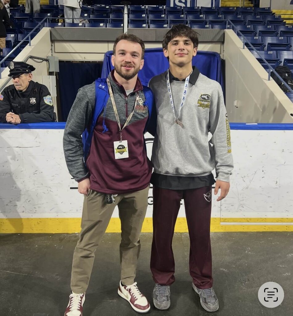 Acton-Carlisle wrestling Coach Peter Charnley and Kyle Amouzgar. Amouzgar outwrestled three higher-ranked competitors to earn a slot in the New England Interscholastic Wrestling Championship this coming weekend. Photo by Kim Amouzgar