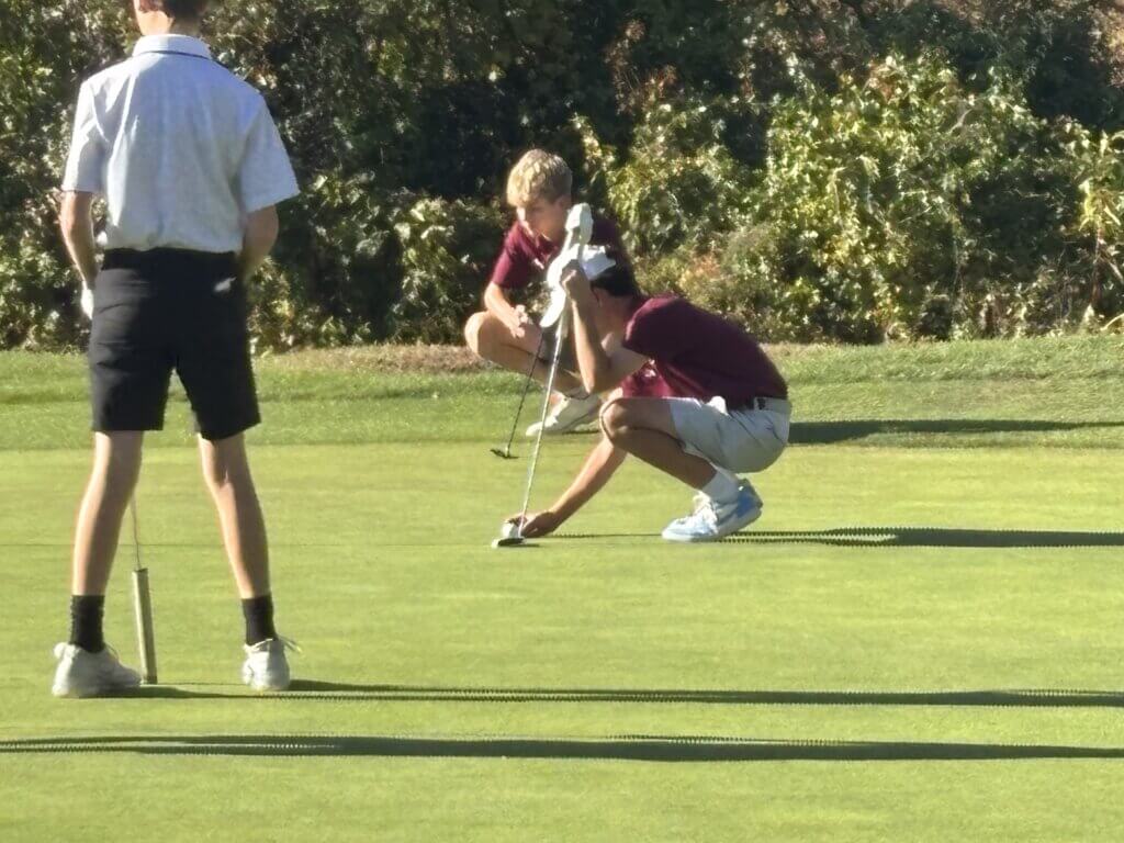 Evan Koder lines up his putt on the seventh hole at Patriot Golf Course in Bedford as playing partner Ben Brooks looks on. Photo by Carl Sweeney