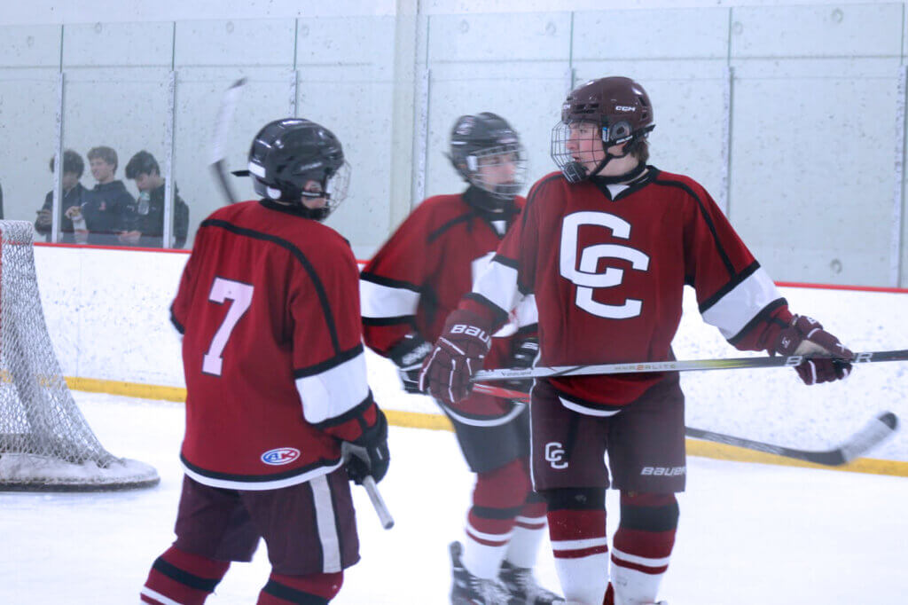 James Jenny, Ryan Terry, and Alex Sherman huddled together in the corner