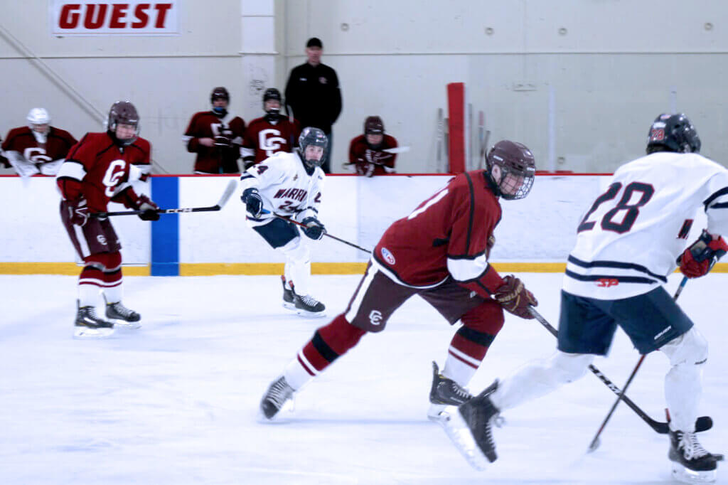 Will Fairbank carries the puck into the offensive zone trailed by Wes Morse