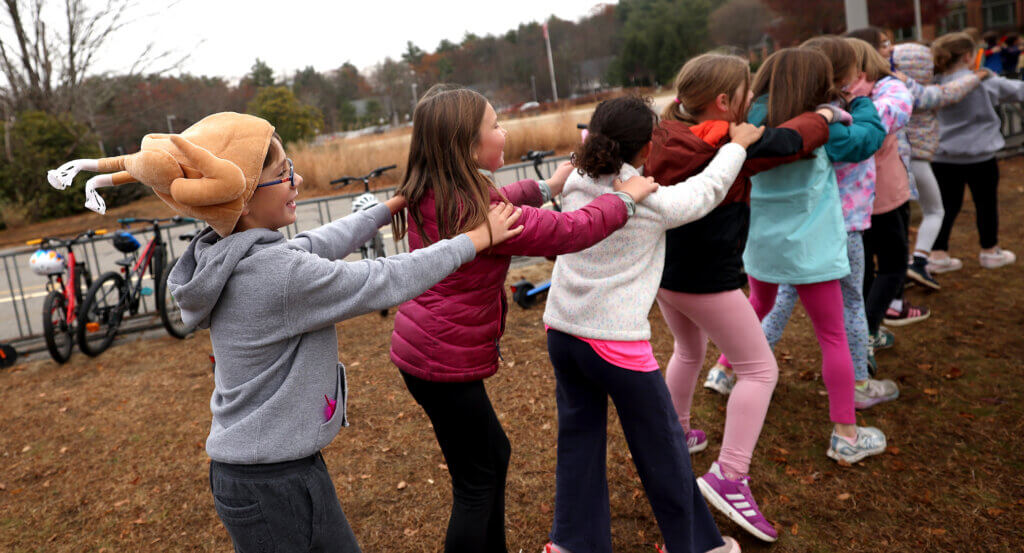 Wearing his turkey hat, Acton third grader John Nadzo brings up the rear of a conga line back inside the building after students ran the Turkey Trot on Friday, November 21, 2025. Ken McGagh/The Acton Bridge
