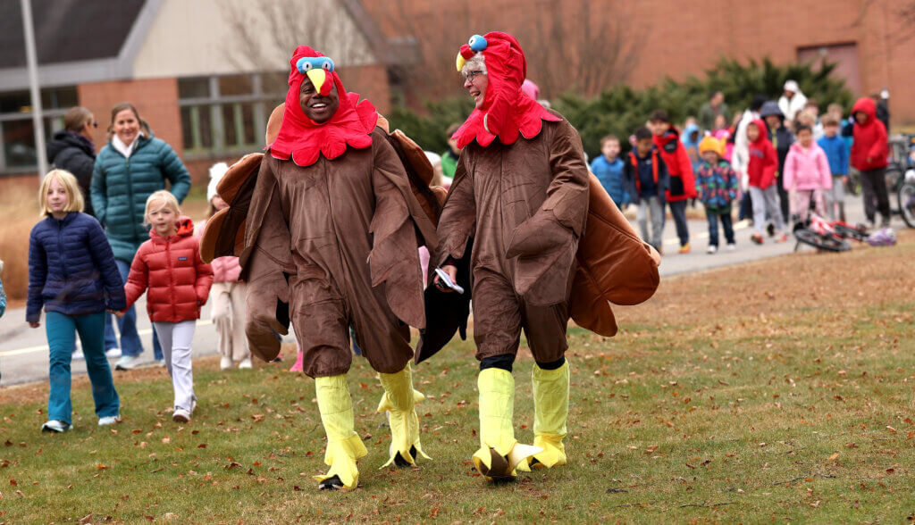 Willard Elementary School principal Matt Lucey, right, and physical education teacher Dave Corbett lead their charges outside for the annual pre-Thanksgiving Turkey Trot on Friday, November 21, 2025. Ken McGagh/The Acton Bridge