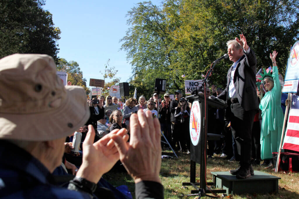 No Kings emcee Jimmy Tingle rallies the crowd beside the historic Buttrick Mansion. Photo: Dakota Antelman/The Acton Bridge