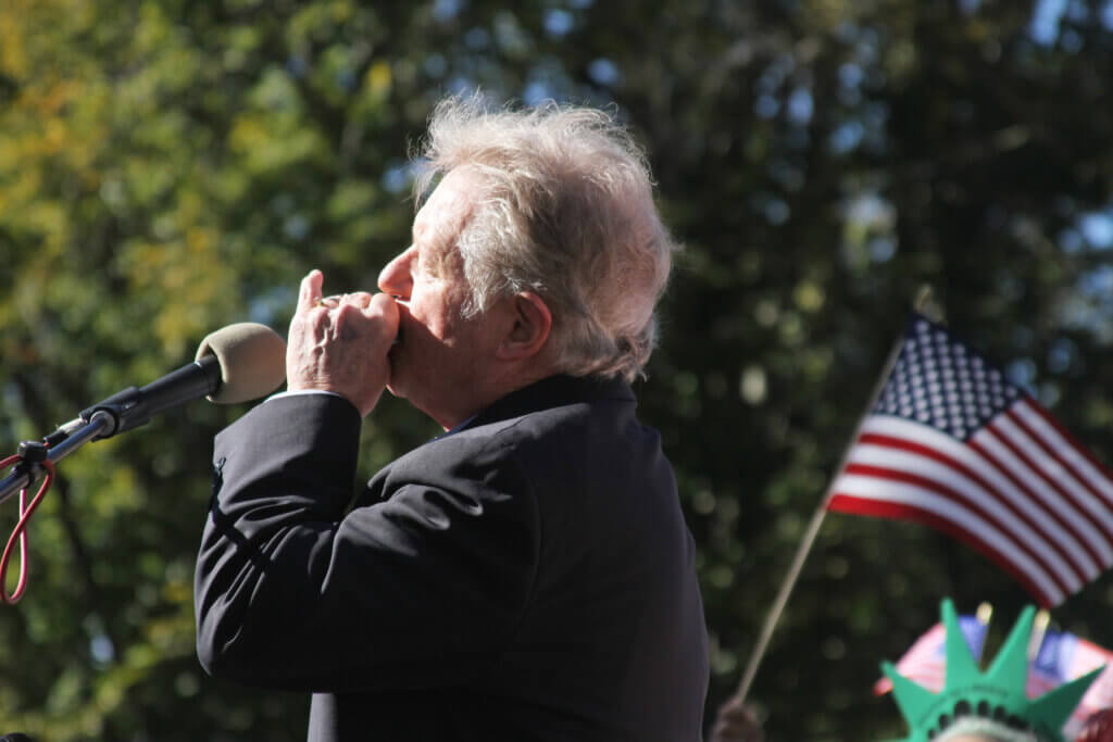 Jimmy Tingle plays the national anthem on his harmonica. Photo: Dakota Antelman/The Acton Bridge
