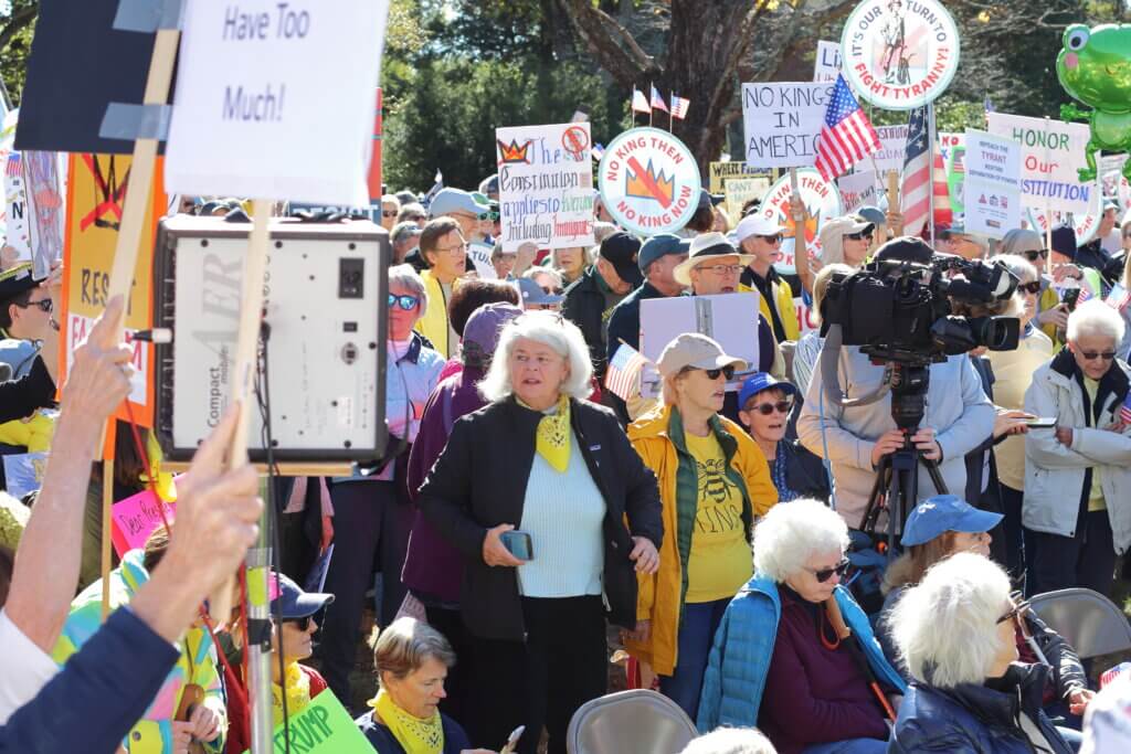 Attendees crowd the front of the rally near the microphone to see the speakers. Photo: Trace Salzbrenner/The Acton Bridge