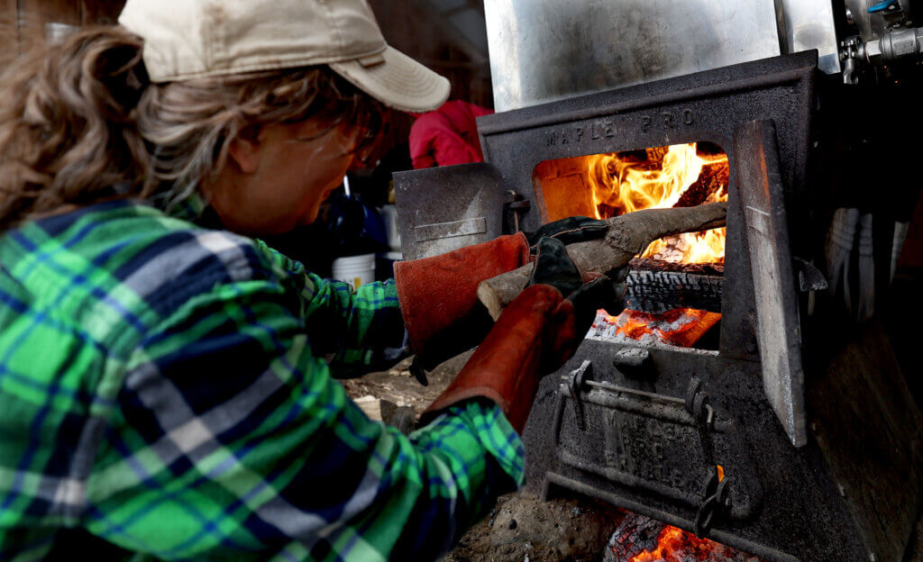 Farm manager Johanna Flies feeds the sugar shack’s wood fire. Ken McGagh/The Acton Bridge