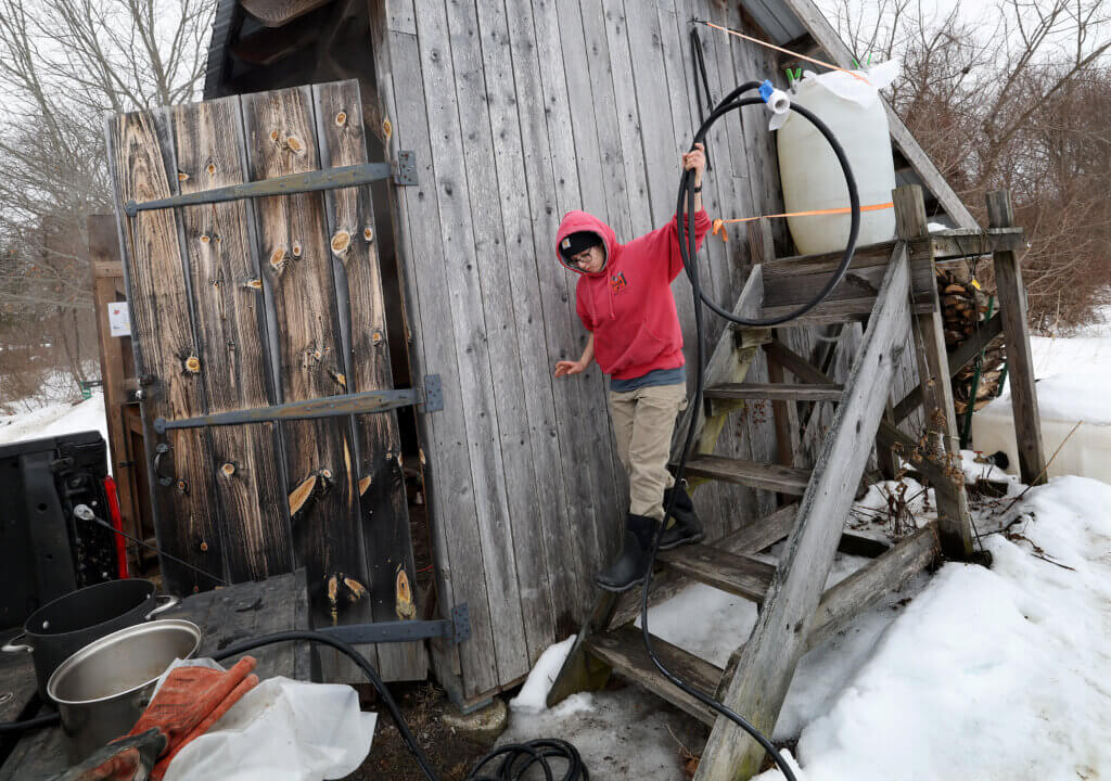 Gaining Ground’s Ava Lublin carries hose into the farm’s sugar shack on Thursday, March 5, 2026. Ken McGagh/The Acton Bridge