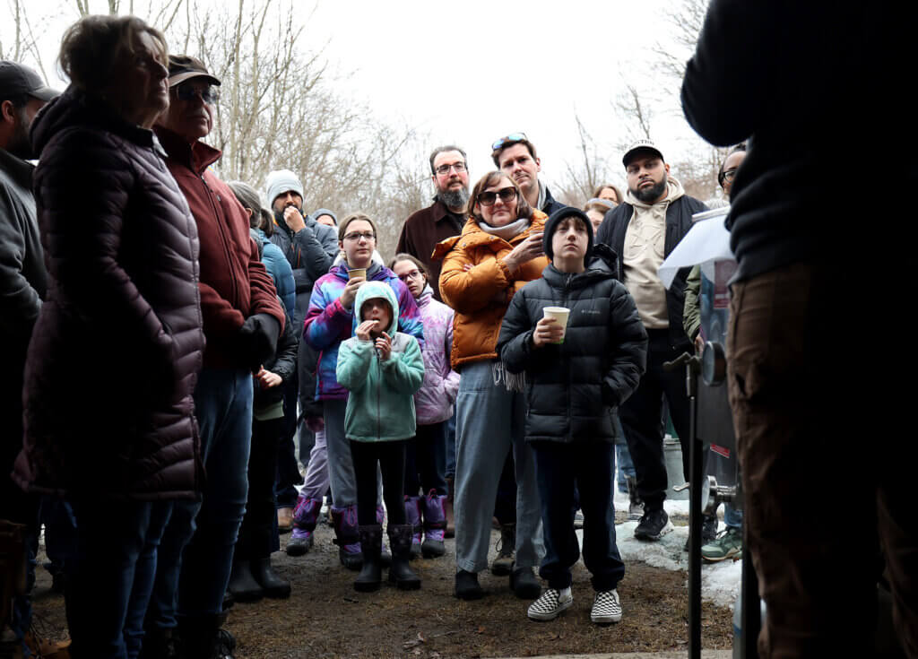 Visitors huddle at the entrance of the Gaining Ground sugar shack to learn about the maple sugaring process during an open house on Saturday,  March 7, 2026.  In 2025 the farm created 161 pounds of maple syrup.  2024 was much worse, with 43 pounds of the final product.