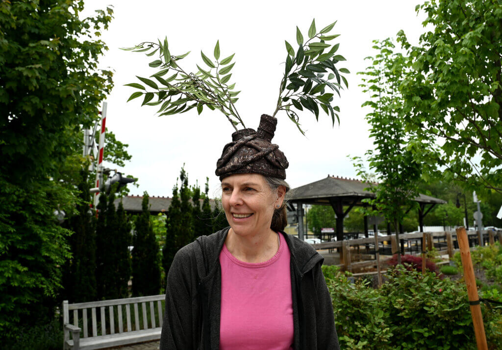 Christa Collins and her plant headdress blend right in while working the Acton Setback Tree Planting Program and Acton 250 Tree Project booth.