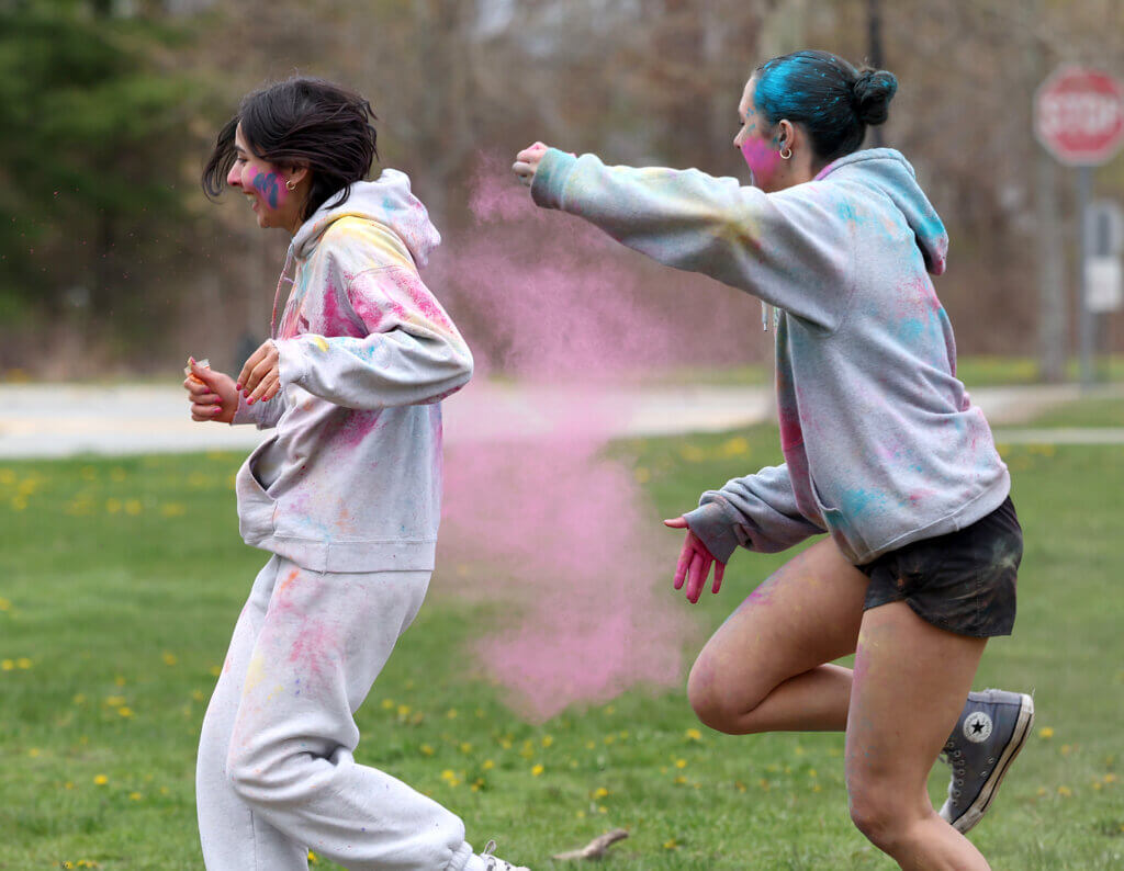Kamala Bose, right, gives chase to Shanti Samnotra, during a Holi Celebration at the Alcott Elementary School playground on Saturday, May 2, 2026. Both are 17 and students at Acton-Carlisle High School. Ken McGagh/The Acton Bridge