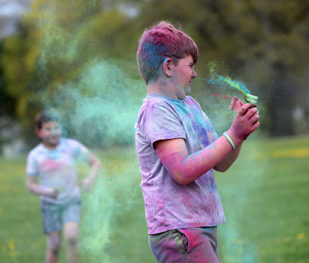 Owen Little, 10, of Acton, douses himself in colored powder during a Holi Celebration at the Alcott Elementary School playground on Saturday, May 2, 2026. Ken McGagh/The Acton Bridge