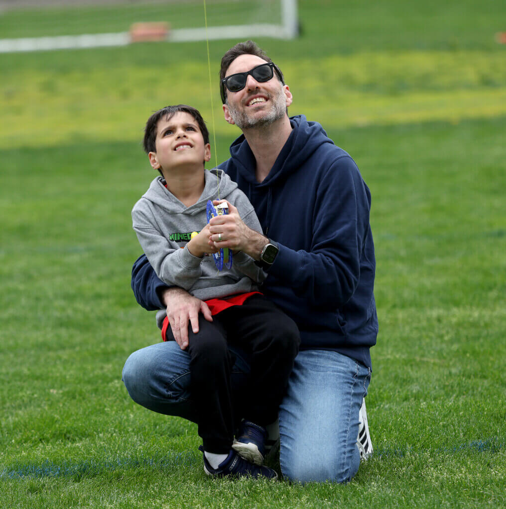 Mohammad Jouni of Acton and his son Oliver, 5, watch as their kite soars a thousand feet over Rideout Park in West Acton during the Acton Recreation Department’s Kite Festival on Saturday, May 2, 2026. Ken McGagh/The Acton Bridge