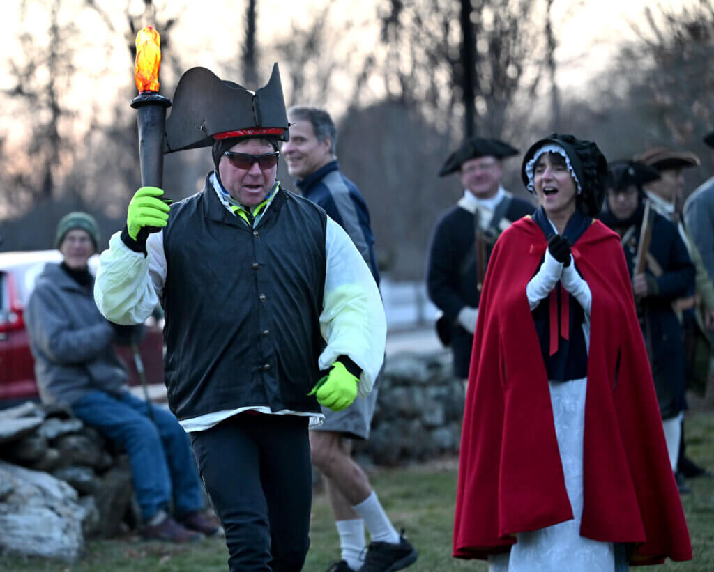 Tim Wilson of Wilmington carries an LED torch to light the Concord250 lantern. Wilson led a procession of cyclists from the Old North Church in Boston to Acton in homage to patriots’  lanterns used to signal the movement of British troops in mid-April 1775. Photo: Ken McGagh/The Acton Bridge
