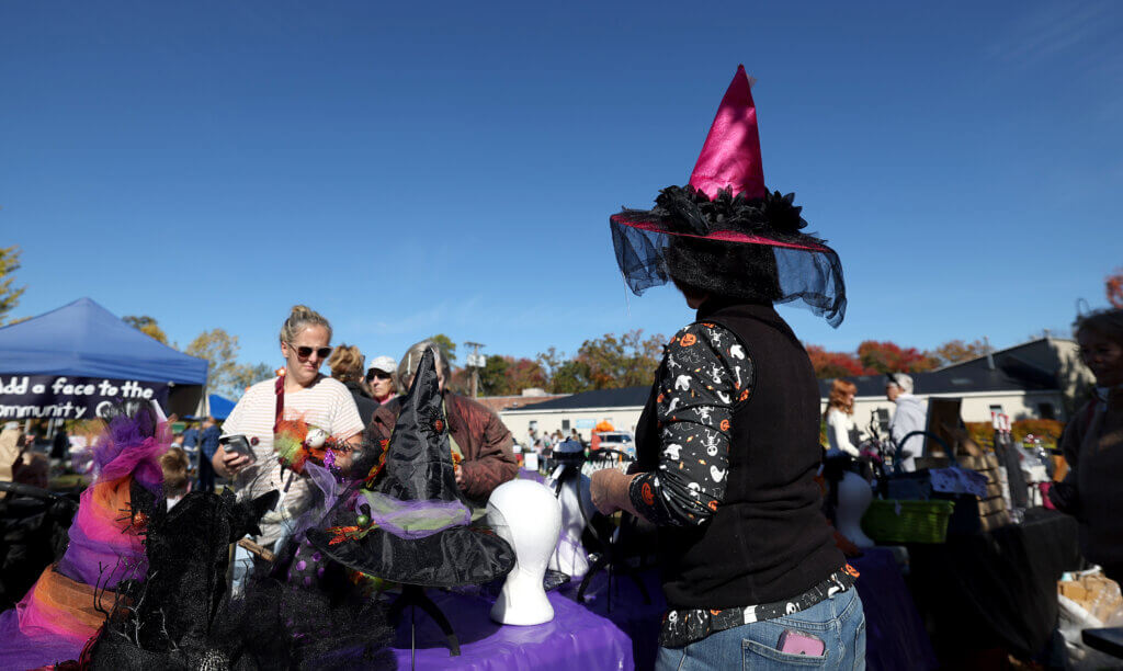 Meg Gaudet, former owner of the A New Leaf consignment shop in West Acton, wears one of her creations while working from behind her booth at Discover West Acton Day on Saturday, October 18, 2025. Ken McGagh/The Acton Bridge