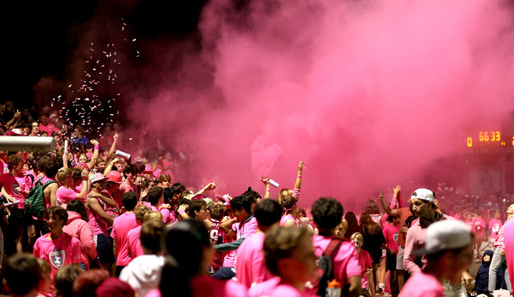 Pink smoke and confetti fill the air during the battle with Lincoln-Sudbury.
