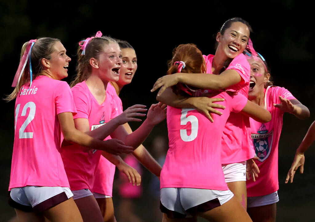 Natalie Saak, right, is hugged by teammate Braeden Peca (No. 5) after providing the game-winning goal late in the fourth quarter.