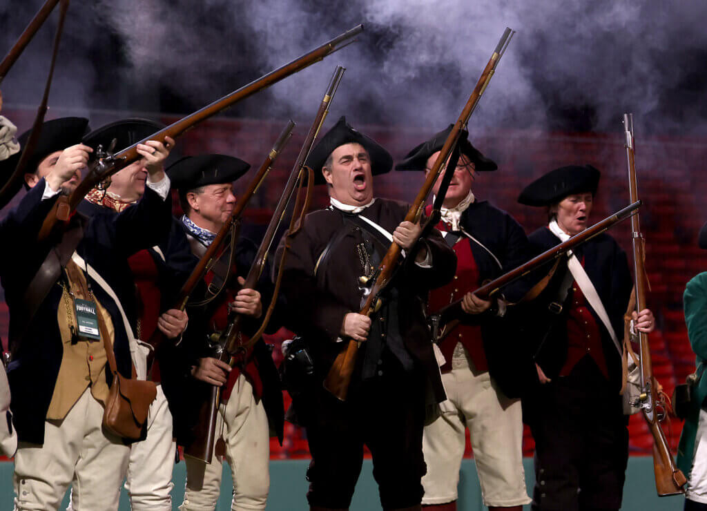 The Acton Minute Men cheer after firing a musket volley following a Patriots touchdown.
