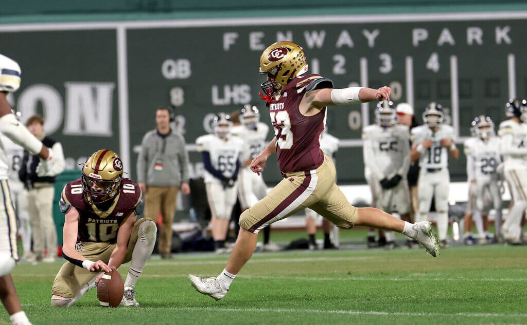 Acton-Carlisle’s Eric Nick kicks for an extra point as teammate Christian Meyer holds the ball during the second half.
