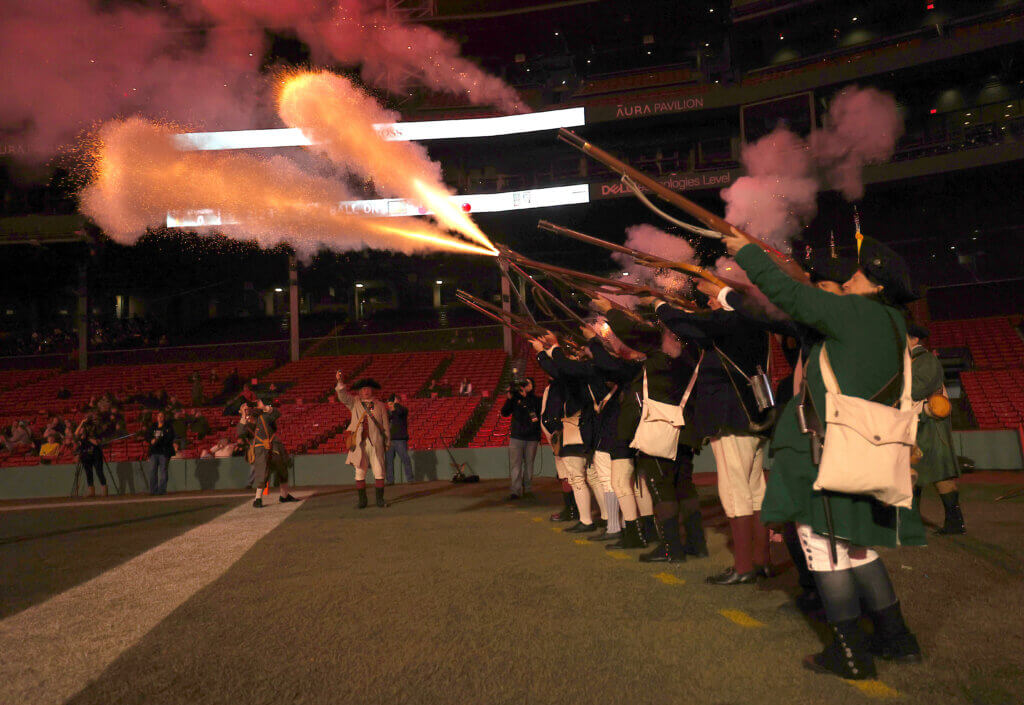 The Acton Minute Men fire a musket salute after a Patriots fourth-quarter touchdown.
