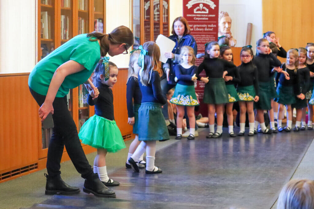 Meghan Allen, dance instructor and owner of The Innisfree Massachusetts Irish Dance School, helps the younger dancers show off what they have learned. Photo: Trace Salzbrenner/The Acton Bridge