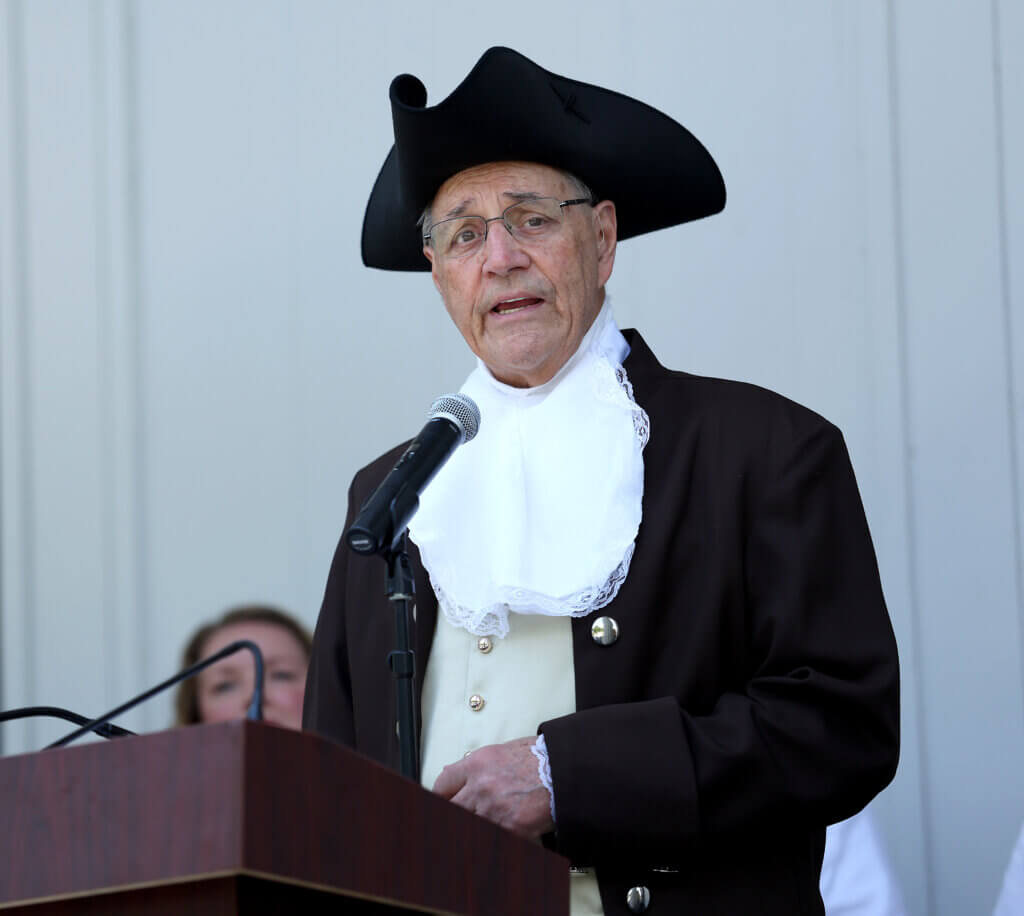 Moderator Tom Wilson of the Wright Tavern Legacy Trust speaks during “Declaring Independence Then and Now In Acton” on the steps of the First Parish in Acton on Saturday, July 11, 2026. Ken McGagh/The Acton Bridge