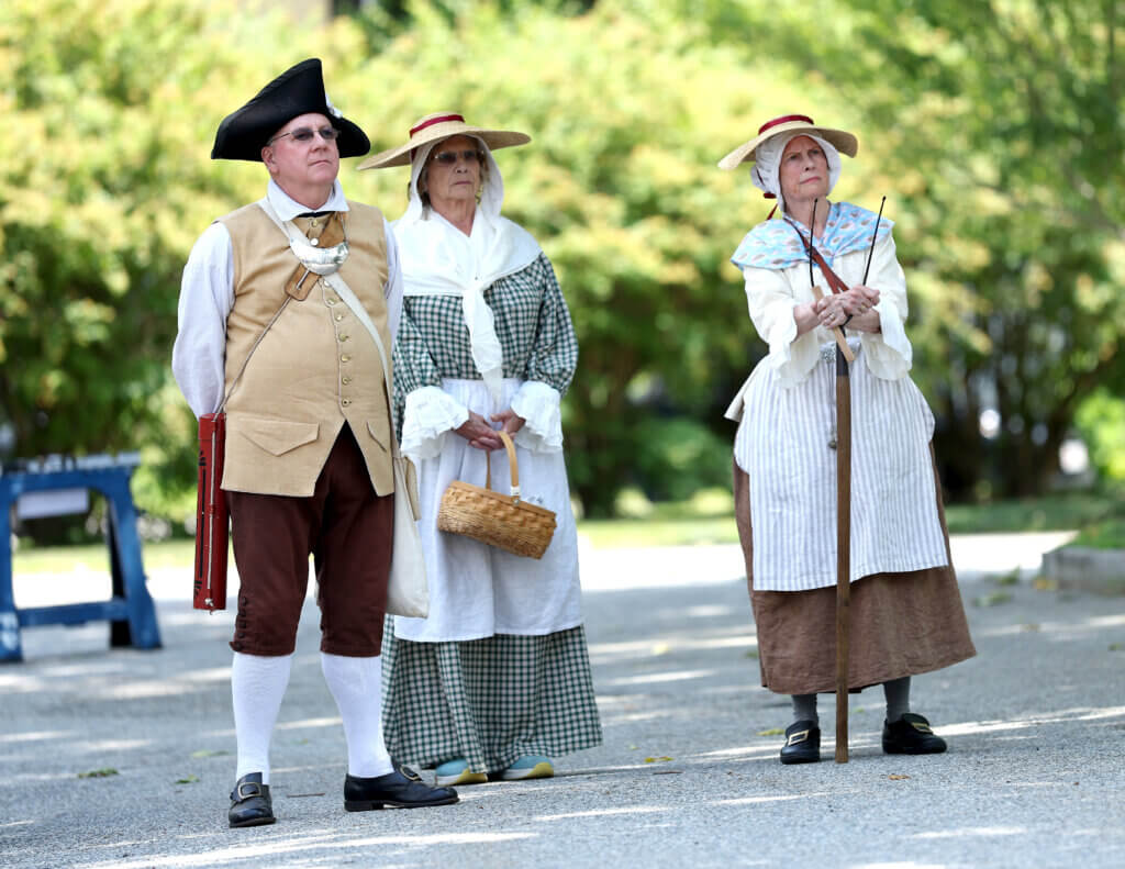 Onlookers in Colonial garb listen during a reading of the Declaration of Independence in Acton on Saturday, July 11, 2026. Ken McGagh/The Acton Bridge