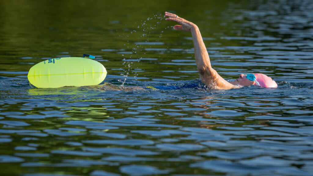 To stay visible and safe, a long-distance swimmer tows a lime-green float. Photo by Jean Fain