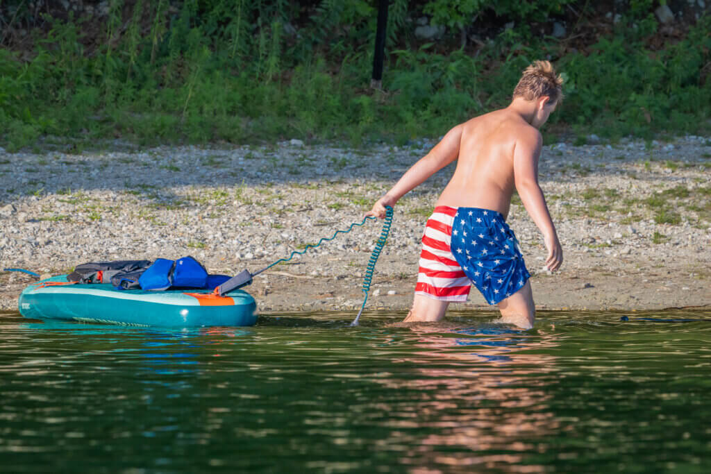 An all-American adventurer pulls his SUP along the shore. Photo by Jean Fain