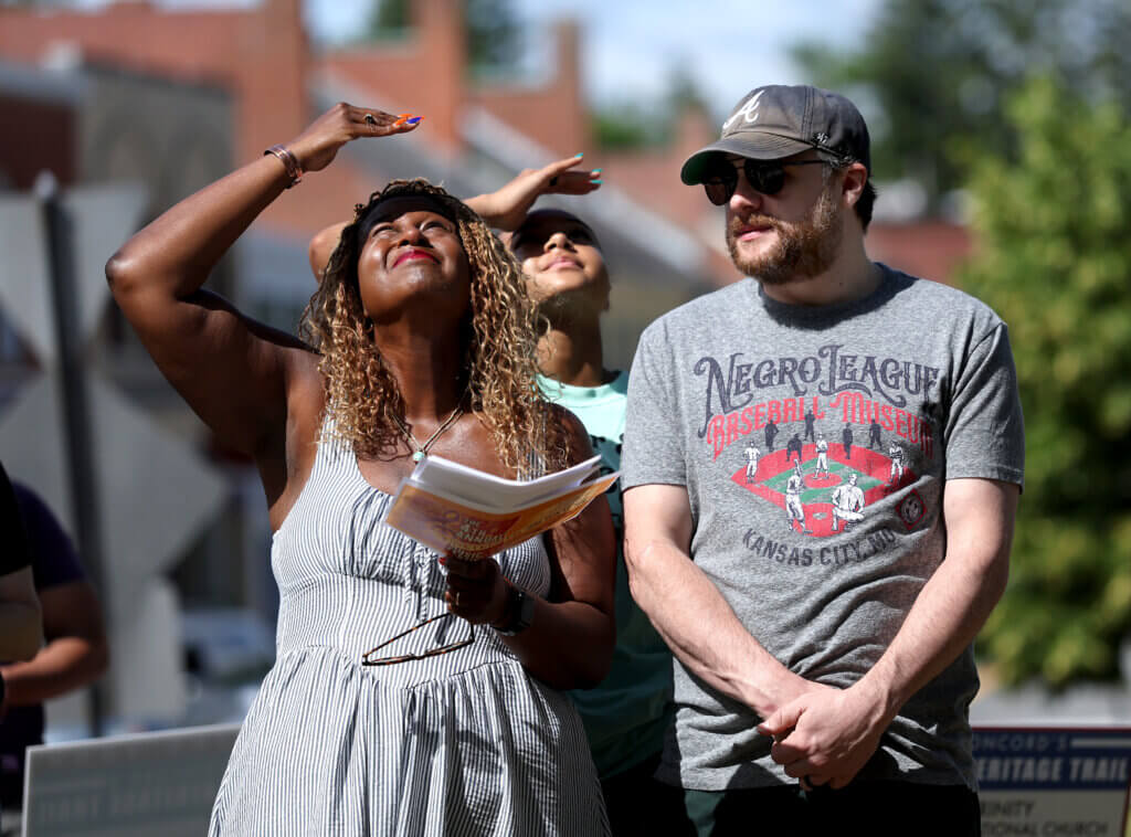 Nikki Turpin, left, board president of The Robbins House, watches as the Juneteenth Flag is raised in Monument Square, with her husband Mike Turpin looking on. Photo: Ken McGagh/The Acton Bridge