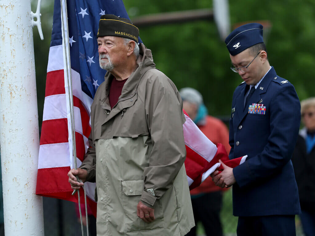 ​​Vietnam War veteran Bob Windheim of Acton VFW Post 10336 and Col. Alan Louie of Hanscom Air Force Base prepare to raise the American flag during a Memorial Day ceremony at Rideout Park in West Acton on Monday.