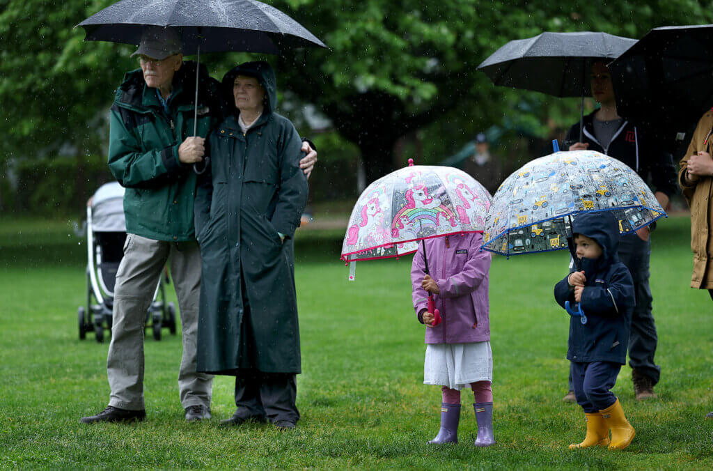 Observers try to stay dry during a rainy ceremony at Rideout Park. Ken McGagh/The Acton Bridge 
