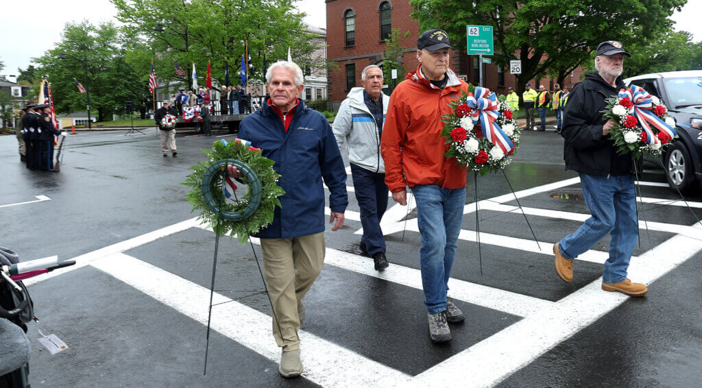Veterans John Mazzeo, left, Joe Delorey, rear, Jack Dalton, center, and John Pierce, right, carry wreaths to be laid at Monument Square war memorials.  Ken McGagh/The Acton Bridge 
