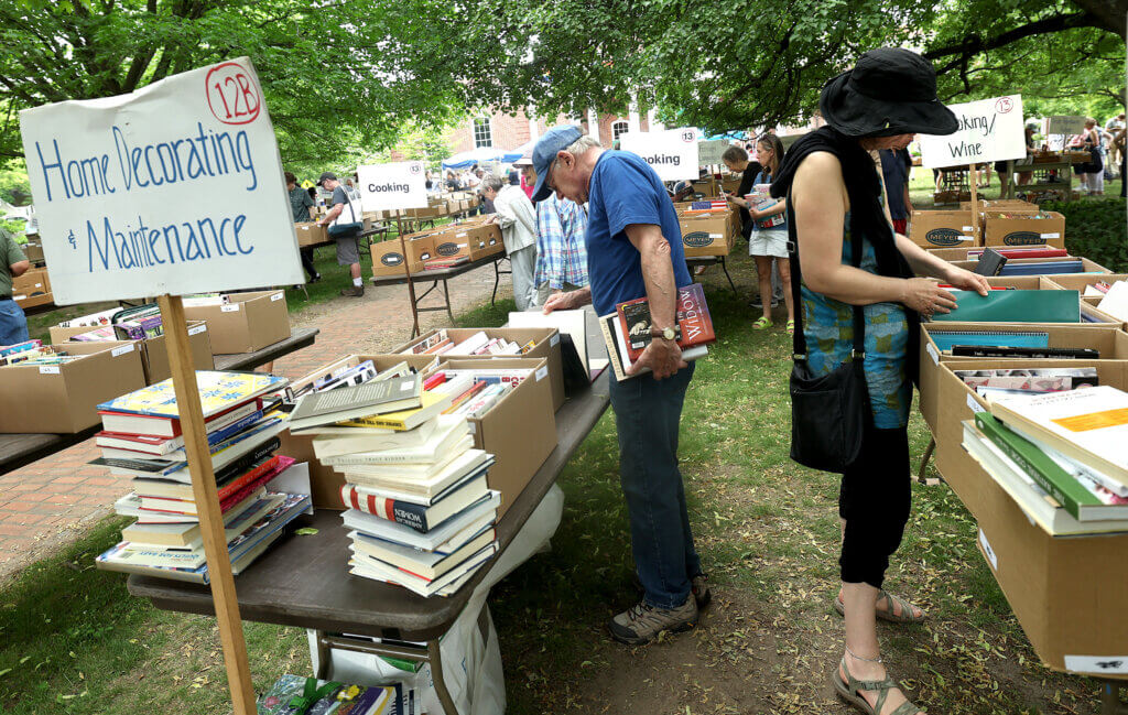 Readers peruse books for sale on the library lawn.