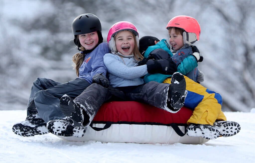 Acton siblings Anna Pavlik, 11, left, Claire Pavlik, 9, and Roger Pavlik, 7, zoom down a slope at Acton-Carlisle High School on Monday, January 19. Joining them on the tube were Ellis Tumminello, 7, and Addy Tumminello, 5, also of Acton.